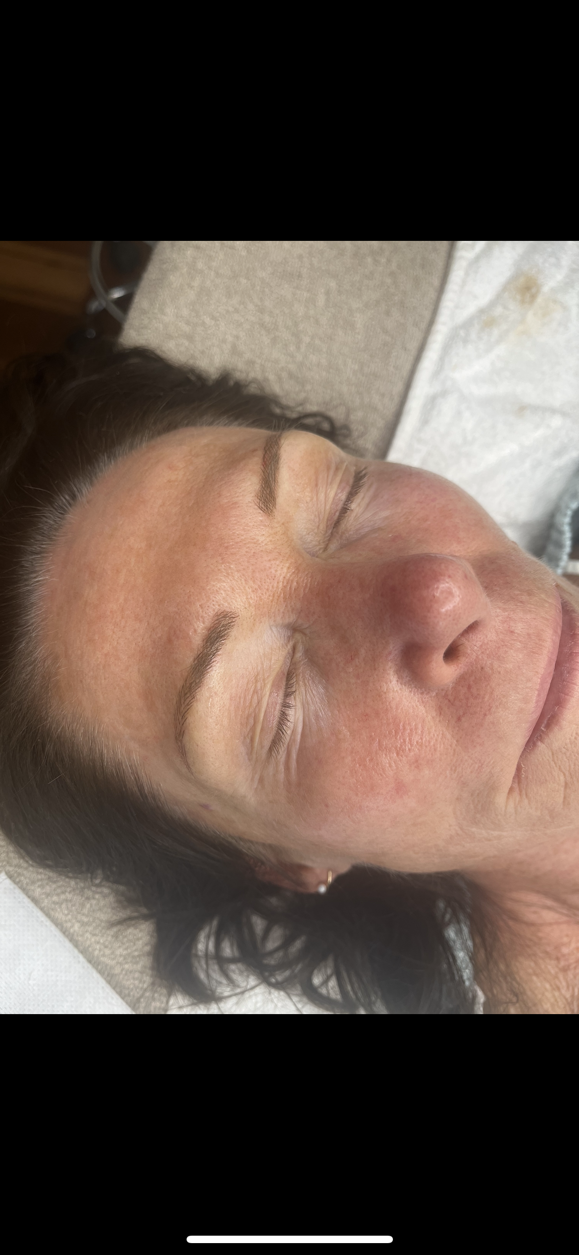 Freshly microbladed brows with fine hair strokes, shaped to the client's brow bone
